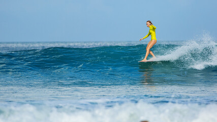 beautiful surfer girl rides a longboard