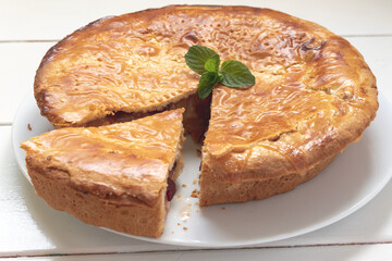 Traditional homemade apple pie with cranberries. complete cake on a wooden white table