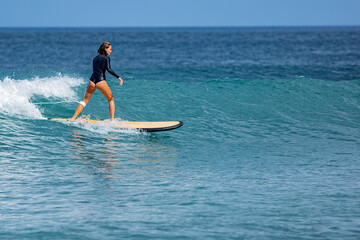 Fototapeta na wymiar beautiful surfer girl rides a surfboard