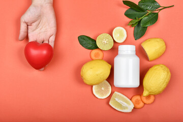 Heart model and Vitamin nutrition pills with fresh fruit and vegetable, Healthy diet, Vitamin and mineral supplement, Nutrition food as a prescription for good health.