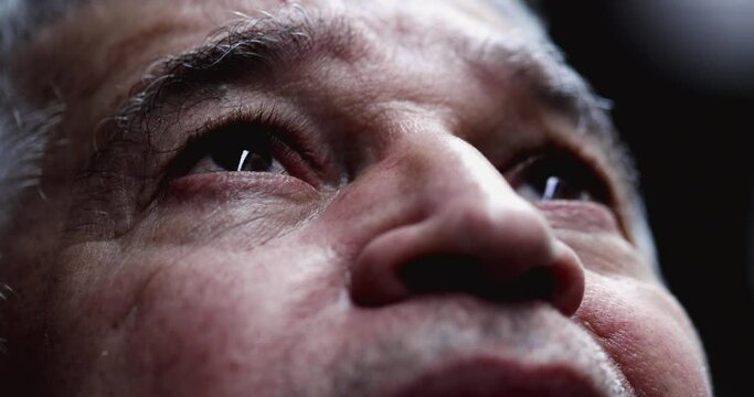 Older man opening eyes lifting head up, close-up senior eye in contemplation