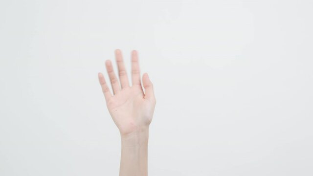 Close up of woman hand showing waving bye on the white background.
