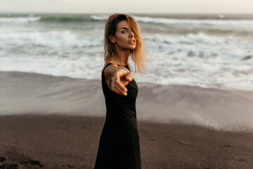 woman on beach is enjoying serene ocean nature during travel holidays vacation outdoors sunset time