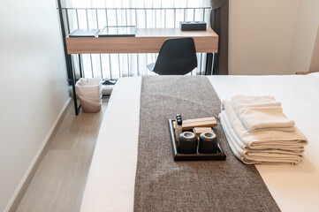 Set of hotel amenities (such as towels, shampoo, soap, toothbrush etc) on the bed.