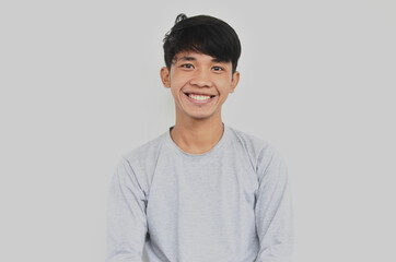 A portrait of a young Asian man looking happy