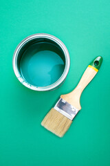 Open paint enamel cans on green turquoise palette samples.