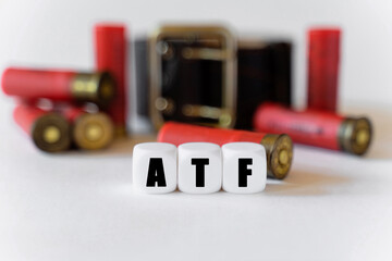 Fototapeta Against the background of cartridges and a military belt, cubes with the inscription - ATF obraz