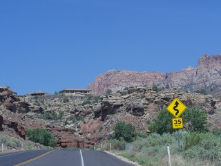 Roadside signs warning travelers of a zigzag road ahead and the speed limit at Zion National Park,...