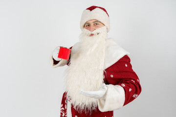 Santa Claus holds a mug in his hands, drinks tea.