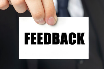 Businessman shows a card with the text FEEDBACK