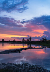 Fototapeta premium sunset sky vertical over the lake in the evening with colorful sunlight 