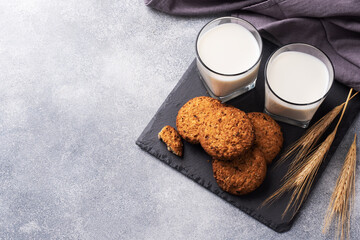 Homemade cookies cereals oats and a glass of milk on the grey concrete table. Copy space.