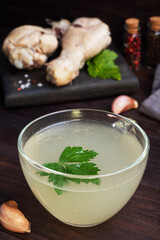 Chicken broth in a glass Cup. Boiled chicken leg quarters. Healthy food with collagen and amino acids.