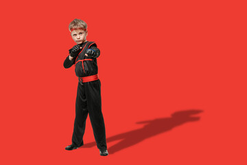 Teen boy in kimono exercising new techniques during taekwondo training