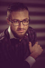Portrait of young handsome smart man correcting glasses. image toned in warm colors in retro style