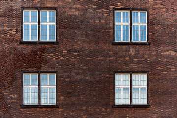Facade of brown brick building with four windows