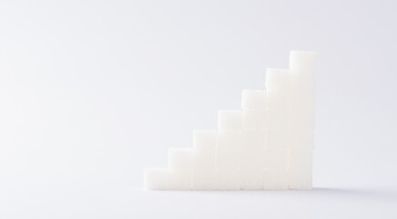 Ascending stacks of sugar cubes graph chart, studio shot isolated on white background, health high blood risk of diabetes concept