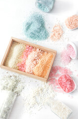 Composition with multi colored sea salt on a white background.