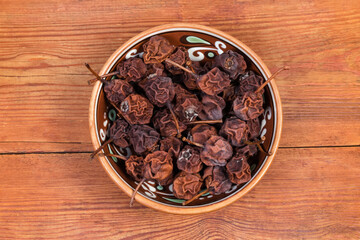Dried wild pears in bowl on rustic table, top view