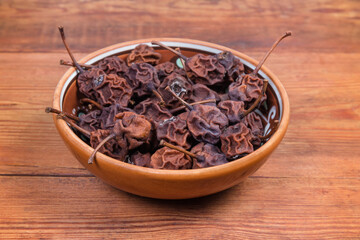 Bowl with dried wild pears on the rustic table, closeup