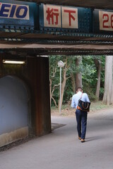 person walking under bridge