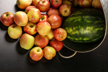 Ripe red apples and watermelon in washtub on dark background top view