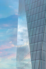 Fototapeta na wymiar Colorful cloudy sky reflected in the exterior glass facade of a modern corporate building