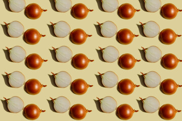 Vegetable pattern. Repeating whole and halves of a round onion on a light yellow background.Beautiful pattern from natural vegetables. Horizontal. The concept of healthy food and vegetarianism.