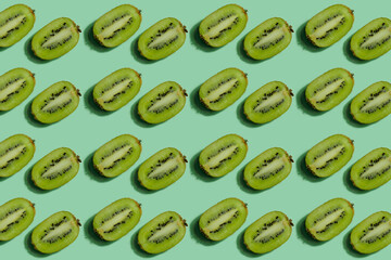 Fruit pattern. Repeating kiwi halves on a green background. Bright fruit pattern made from natural fruits. Horizontal. The concept of healthy food and vegetarianism.