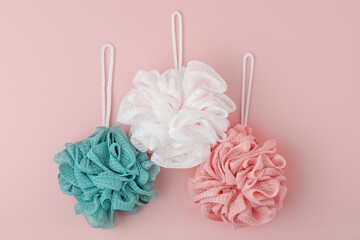 set of colored washcloths on a pink background, top view