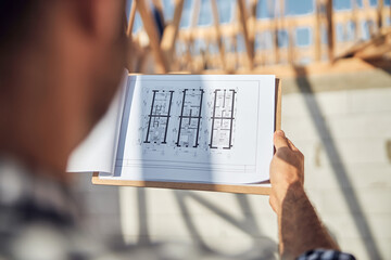 Experienced field engineer looking at schematic plan of a building