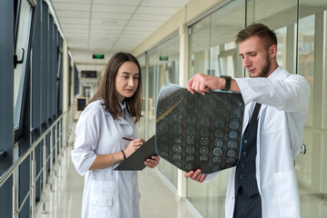Obraz premium Two doctors discuss the results of X-ray MRI images of the patient?s brain in hospital