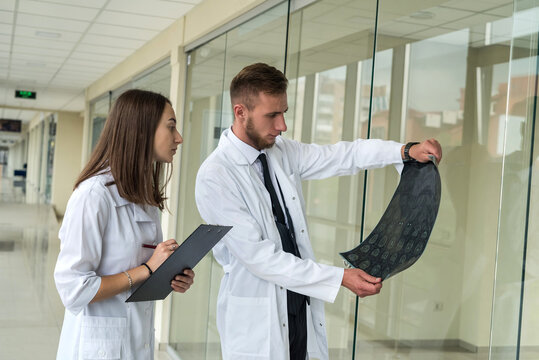 two  intern doctors looking MRI of the brain for succses head injury treatment