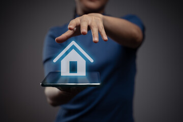 Woman using tablet with home icon hologram effect.