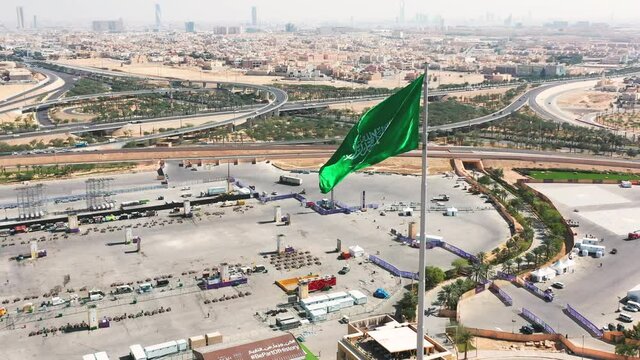 Aerial view of Riyadh with the Kingdom of Saudi Arabia flag waving on the wind / 4K #3