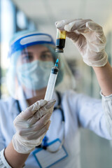 Woman doctor wearing uniform holding syringe in clinic