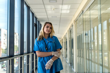 Pretty nurse in blue uniform with stetoscope indoors in modern clinic