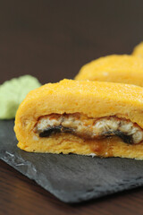 Japanese Roll with breading isolated on white background. Asian Hot Roll pieces with Unagi eel, cucumber, Philadelphia cheese and Tamagoyaki egg omelet (Tamago). Food menu isolation.