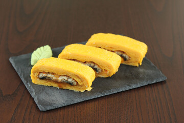Japanese Roll with breading isolated on white background. Asian Hot Roll pieces with Unagi eel, cucumber, Philadelphia cheese and Tamagoyaki egg omelet (Tamago). Food menu isolation.
