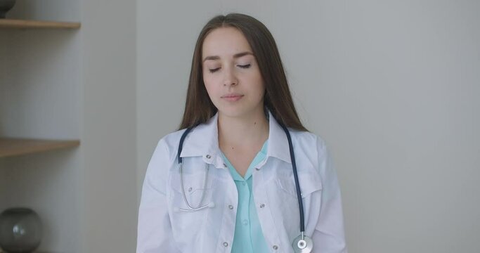Looking at the camera listening woman doctor looks at the camera and listens to the patient. A video conference listener. Portrait of a doctor