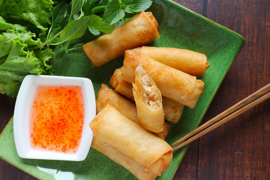 Fried spring rolls or egg rolls ( Por Pia Tord) with sweet chili sauce on the wooden background - Top view