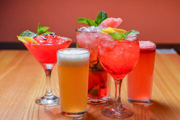 Summer cocktails and soft drinks with pieces of fruit on wooden table. Refreshing summer beverage for hot weather.