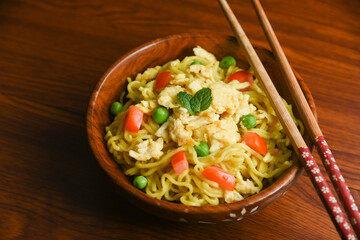 Vegetarian Schezwan Noodles Vegetable Hakka Noodles or Chow Mein in wooden bowl Schezwan Noodles is indo-chinese cuisine hot dish udon noodles Indonesian fried egg noodle. Indian Instant noodles ramen