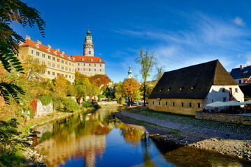 Fototapeta premium Water reflection of State Castle and Chateau Cesky Krumlov, Czech Republic in the Old Town, afternoon with blue sky and beautiful clouds.