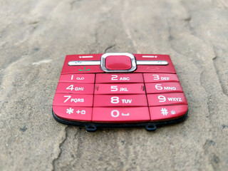 red color broken mobile keypad put on road