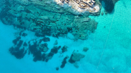 Aerial view of Elba Island. Overhead aerial view of rocks over the ocean. Slow motion.