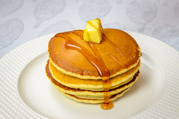 Read to eat sweet Pancake garnished with honey and butter in a round plate