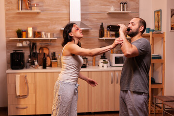 Traumatised wife furious on violent husband during home at night after being abused. Violent...