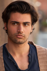 Obraz premium Close portrait of a handsome gorgeous young man with hairstyle. Charming and sensual look.