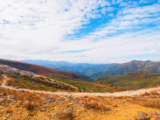 Climber walking on the trail while seeing at autumn leaves